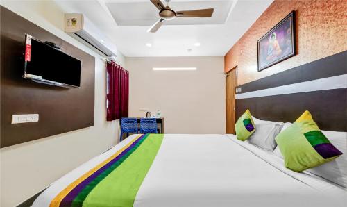 a bedroom with a large bed and a flat screen tv at Treebo Sripadha Residency Alipiri Road in Tirupati