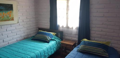 1 dormitorio con cama, almohada y ventana en Casa Jade, en Quintero