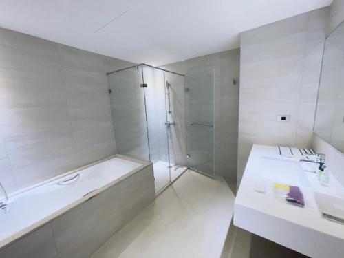 a bathroom with a tub and a shower and a sink at Dahu Park Hotel in Taipei