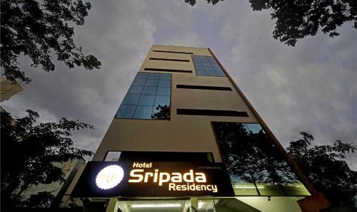 a tall building with a sign in front of it at Treebo Sripadha Residency Alipiri Road in Tirupati