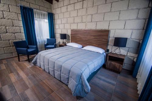 a bedroom with a large bed and a brick wall at Real de Corralejo in San Miguel de Allende