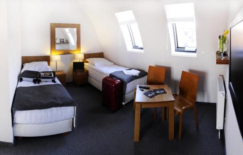 ブィドゴシュチュにあるPrzystan Bydgoszczのベッド2台、テーブルと椅子が備わるホテルルームです。