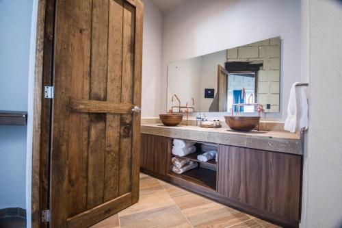 a bathroom with two sinks and a wooden door at Real de Corralejo in San Miguel de Allende