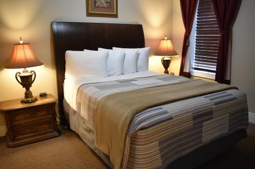 - une chambre avec un grand lit et deux lampes dans l'établissement Silver Horseshoe Inn, à Saint Anthony