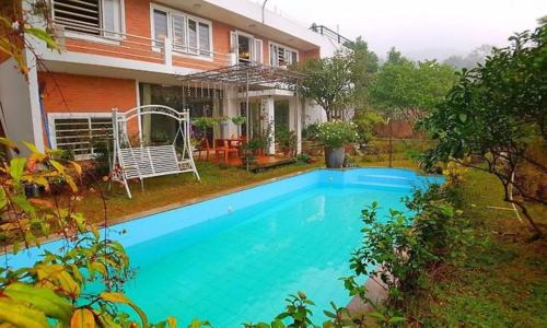 ein großer blauer Swimmingpool vor einem Haus in der Unterkunft Brick Home Villa Sóc Sơn - Venue Travel in Hanoi