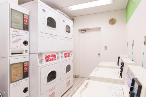 a laundry room with three washer and dryers at FLEXSTAY INN Tokiwadai in Tokyo