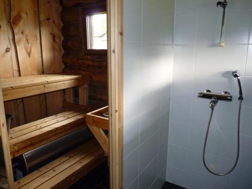 a bathroom with a shower in a wooden cabin at Karhujärven Kelopirtit in Karhujarvi