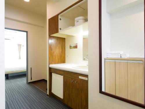 a bathroom with a sink and a mirror at FLEXSTAY INN Tokiwadai in Tokyo