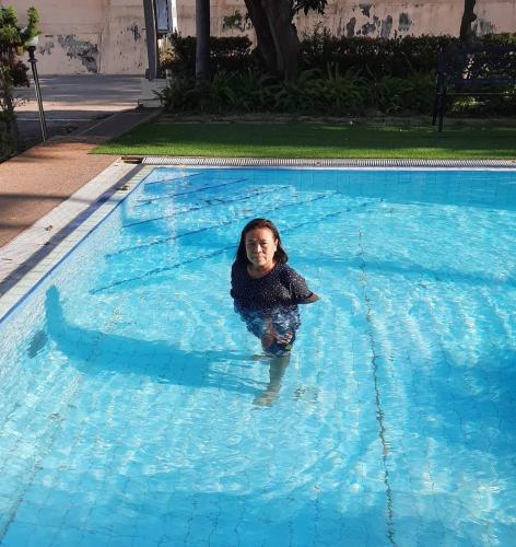 a young girl is swimming in a swimming pool at โรงแรม ชาโตว์วิสต้า in Chon Buri