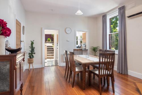 - une salle à manger avec une table et des chaises en bois dans l'établissement Warwick St Retreat! 3 Bedroom House With Parking, à Hobart