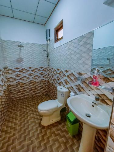 un baño con inodoro y lavabo en Nimsara Lodge Sigiriya, en Sigiriya