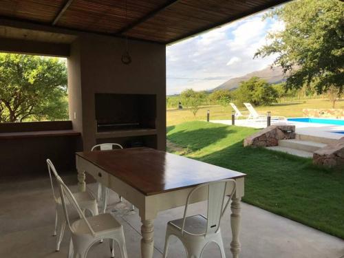 a dining room table with white chairs and a television at SOLSALI Cabaña moderna in San Javier