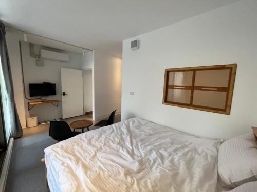 a bedroom with a white bed and a window at Rolling Pin Homestay in Tainan
