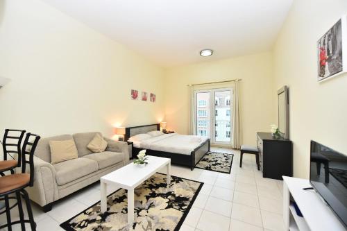 a living room with a couch and a table at Luxury Escapes - Budget Studio with Garden Views near Metro - MED64 DG in Dubai
