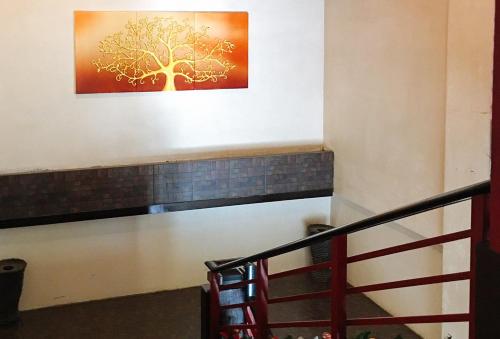 a staircase with a painting of a tree on the wall at RedDoorz @ Mountain Citi Tourist Inn Canlaon in Panubigan