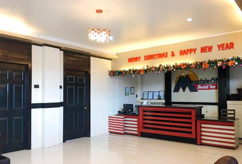 a lobby with a christmas sign on the wall at RedDoorz @ Mountain Citi Tourist Inn Canlaon in Panubigan