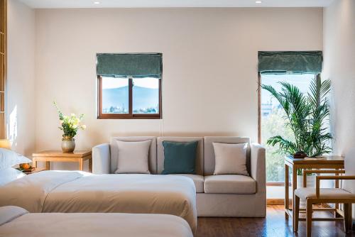 a living room with two beds and a couch at Lijiang Gemmer Hotel in Lijiang