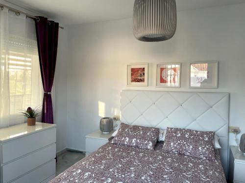 um quarto com uma cama com uma cabeceira branca em Apartamento Torremolinos 2 personas em Torremolinos