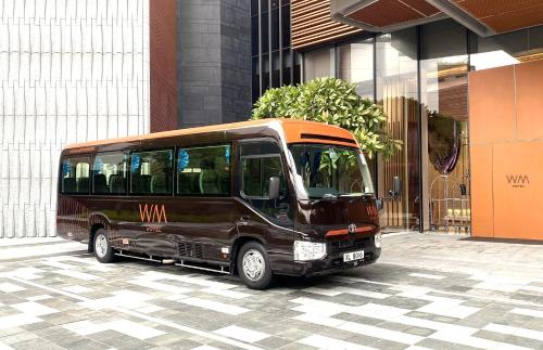 a brown bus parked in front of a building at WM Hotel Hong Kong, Vignette Collection in Hong Kong