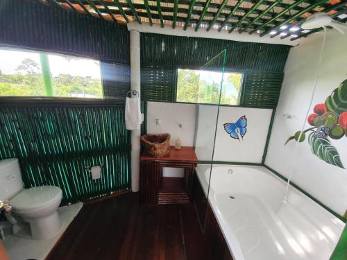 a bathroom with a bath tub and a toilet at Room in Lodge - Tree House Finca La Floresta Verde in Rizaralda