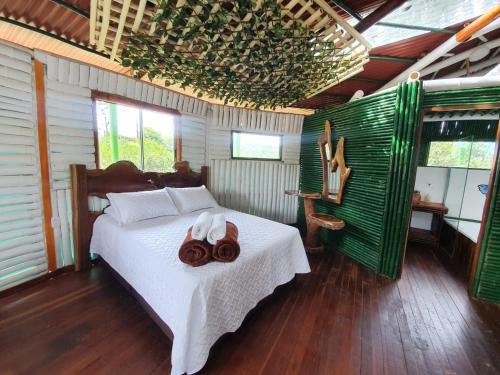 a bedroom with a bed with towels on it at Tree House Finca La Floresta Verde in Rizaralda