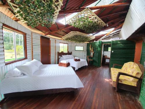 a bedroom with two beds in a room with wooden floors at Room in Lodge - Tree House Finca La Floresta Verde in Rizaralda