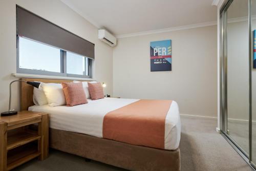a hotel room with a bed and a desk at Airport Apartments by Vetroblu in Perth