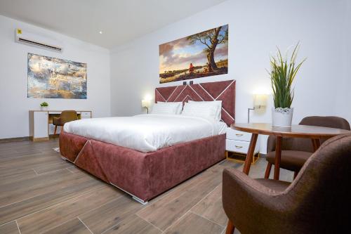 a bedroom with a bed and a table and chairs at Maple Homes in Accra