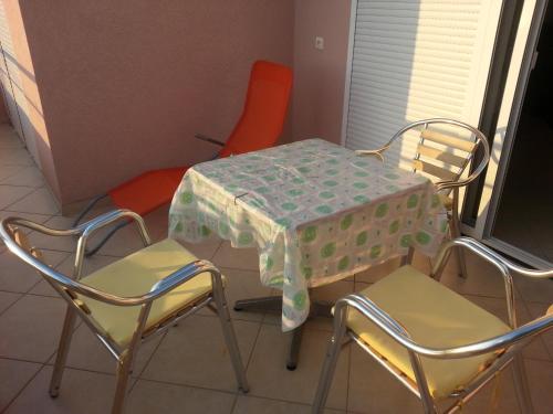 una mesa y sillas con un mantel. en Apartments Nada, en Utjeha