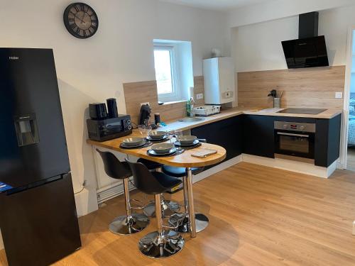 a kitchen with a table with chairs and a counter at le nid douillet de la gare centre ville de Lens in Lens