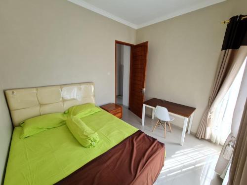 a bedroom with a green bed and a desk at Samadi Villa Batu in Batu