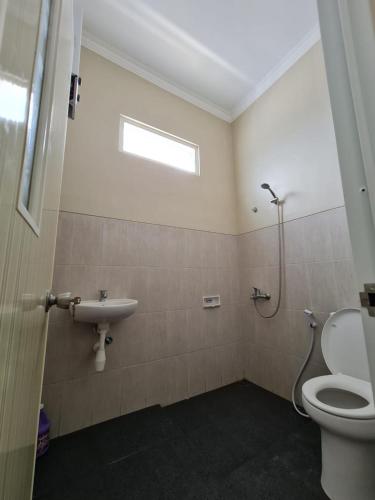 a bathroom with a toilet and a sink at Samadi Villa Batu in Batu