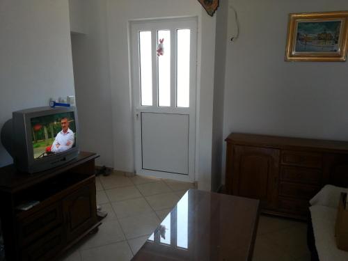 a living room with a door and a tv and a door at Apartments Nada in Utjeha