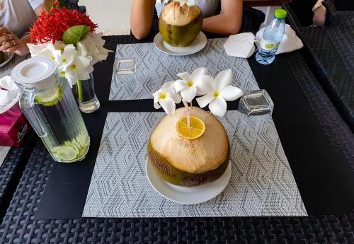a table with two plates of food and flowers on it at Blue Coral Vashafaru Maldives in Vashafaru