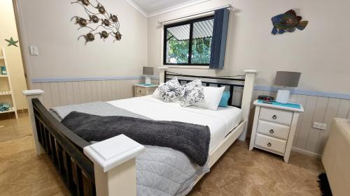 a bedroom with a large bed and a window at Boutique Bungalows in Mission Beach