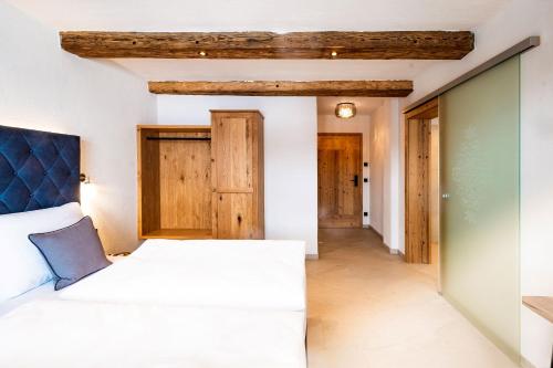 um quarto com uma cama branca e um tecto de madeira em Ferienhaus Mandlberggut by globboard em Schladming