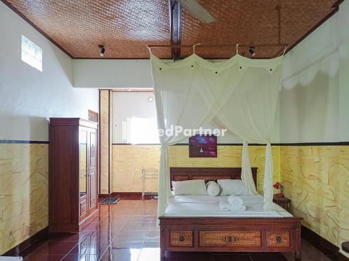sypialnia z łóżkiem z baldachimem w obiekcie Nando House w mieście Ubud