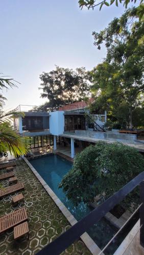 a swimming pool with chairs and a house at Arachchi Heritage in Anuradhapura
