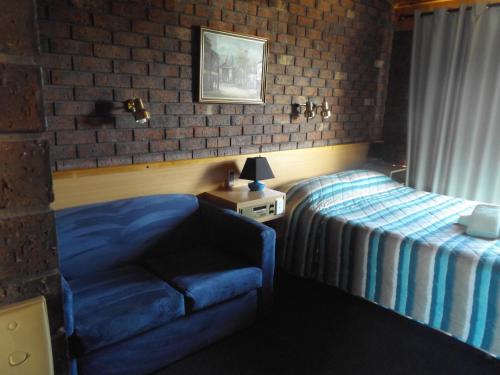 Schlafzimmer mit einem Bett, einem Tisch und einem Fenster in der Unterkunft Rivergum Motel in Echuca