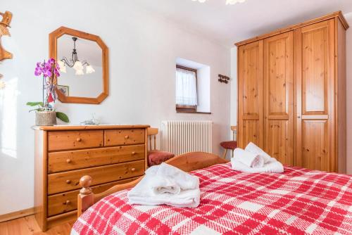 sypialnia z łóżkiem, komodą i lustrem w obiekcie Agritur Alle Quattro Stagioni w mieście Tonadico