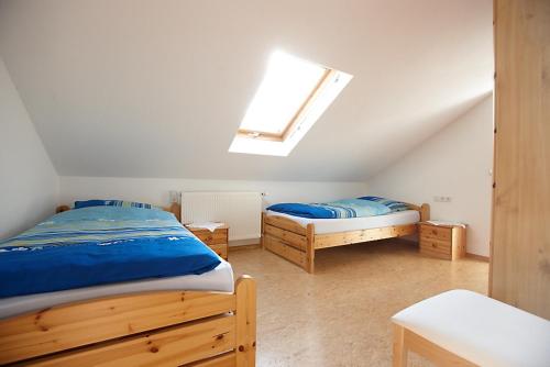 Schlafzimmer im Dachgeschoss mit 2 Betten und einem Dachfenster in der Unterkunft Ferienwohnung Weingut Ackermann in Zeltingen-Rachtig