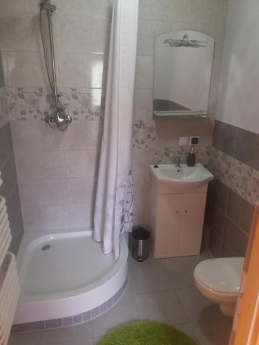 a bathroom with a tub and a toilet and a sink at Apartament "Cichy kącik" in Lubawka