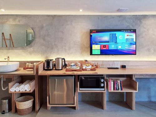 a kitchen with a counter with a tv on the wall at Dodo Studio 1 I Your luxury cosy retreat home in Quatre Bornes