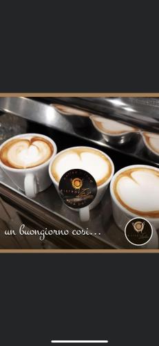 a tray with four cups of cappucino coffees at Herculaneum home in Ercolano
