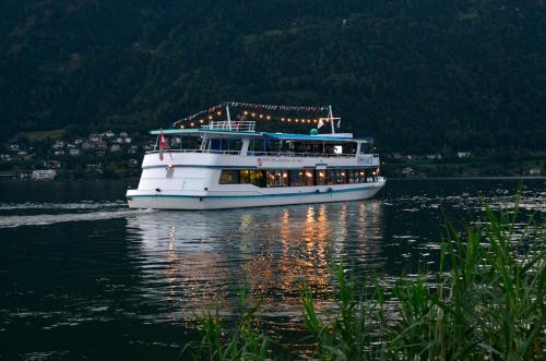 a boat on the water with lights on it at Feriendorf Berghof in Villach