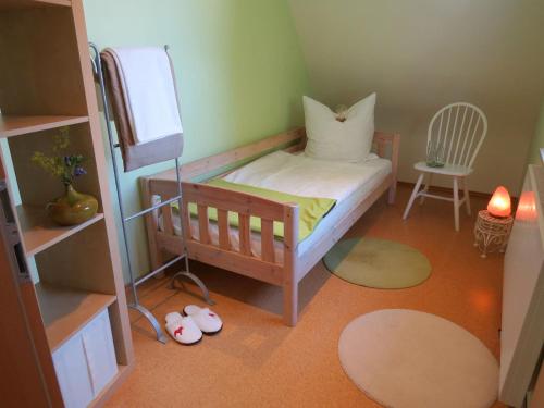 オーバーアスバッハにあるÖkoHausNamastéの小さなベッドルーム(ベッド1台、椅子付)