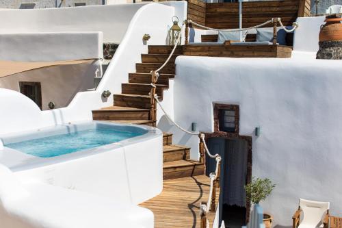 a white house with a plunge pool on the stairs at Gemini Caves in Oia