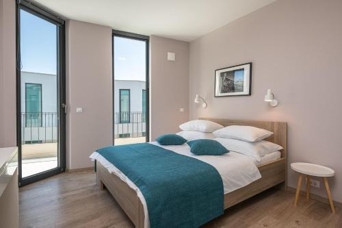a bedroom with a large bed and large windows at Green Hill Penthouse apartment in Korčula