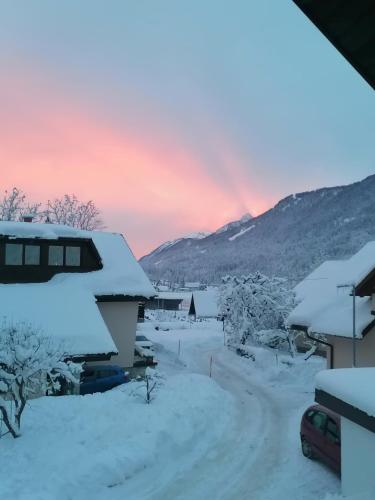 a snow covered yard with a rainbow in the background at Žbogar in Rateče