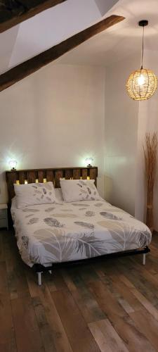 duże łóżko w sypialni z drewnianą podłogą w obiekcie Le 6 bis avec Jardinet w mieście Guéméné-Penfao